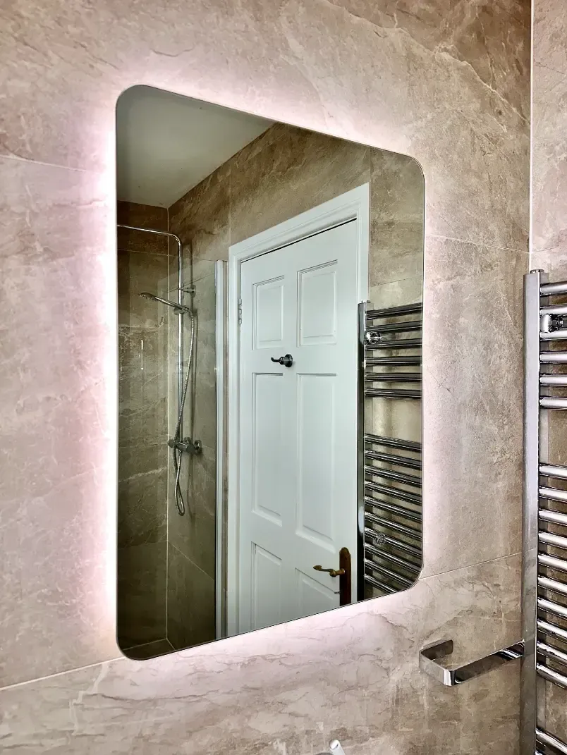 A bathroom with a mirror and a towel rack.
