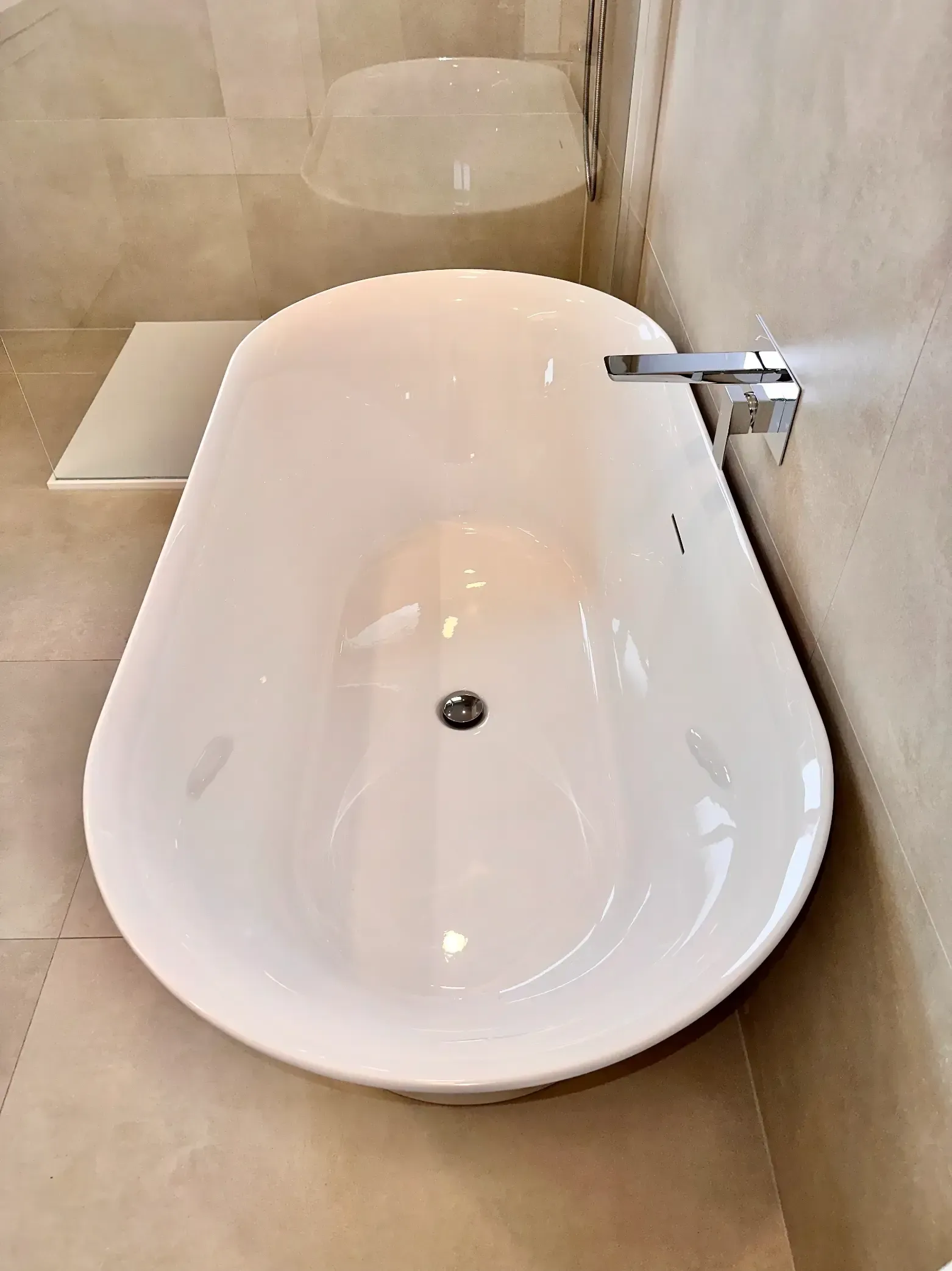 A white bathtub is sitting in a bathroom next to a toilet.