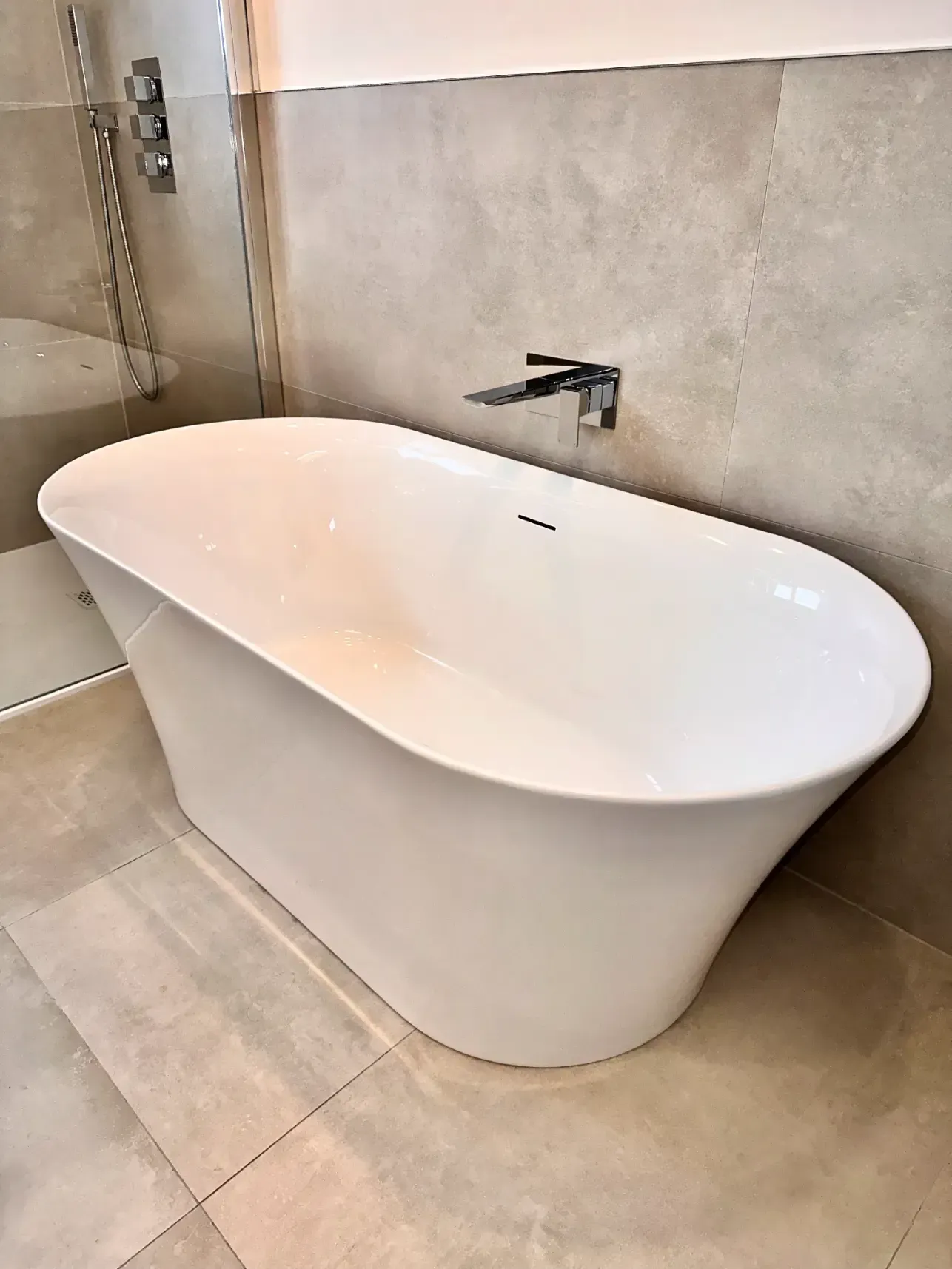 A white bathtub is sitting in a bathroom next to a shower.