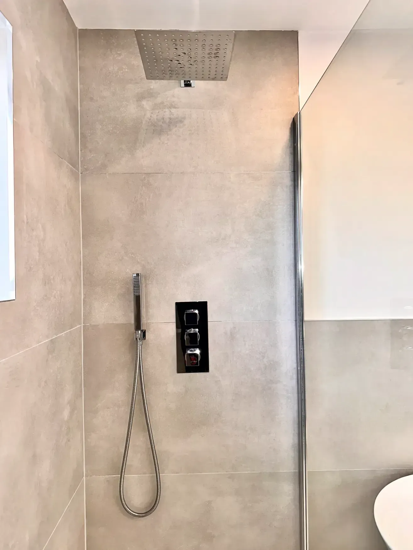 A bathroom with a shower head and a toilet.