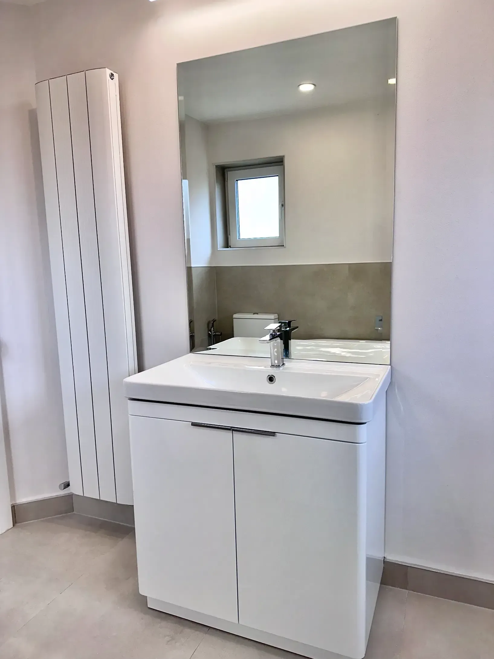 A bathroom with a sink and a large mirror