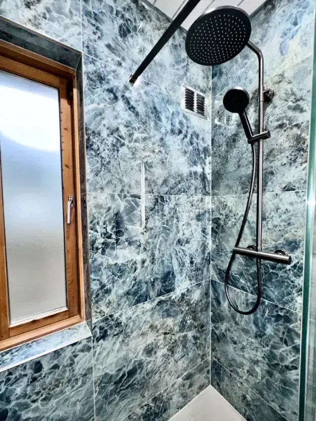 A bathroom with a shower and a window.