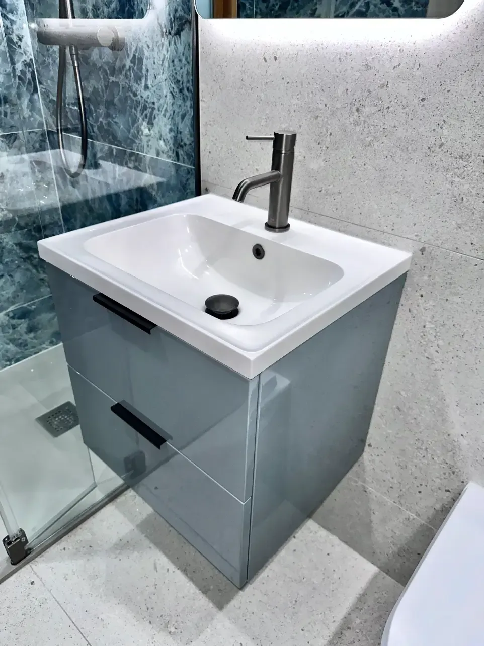 A bathroom with a sink , mirror and shower.