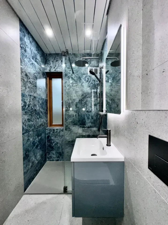 A bathroom with a sink and a walk in shower
