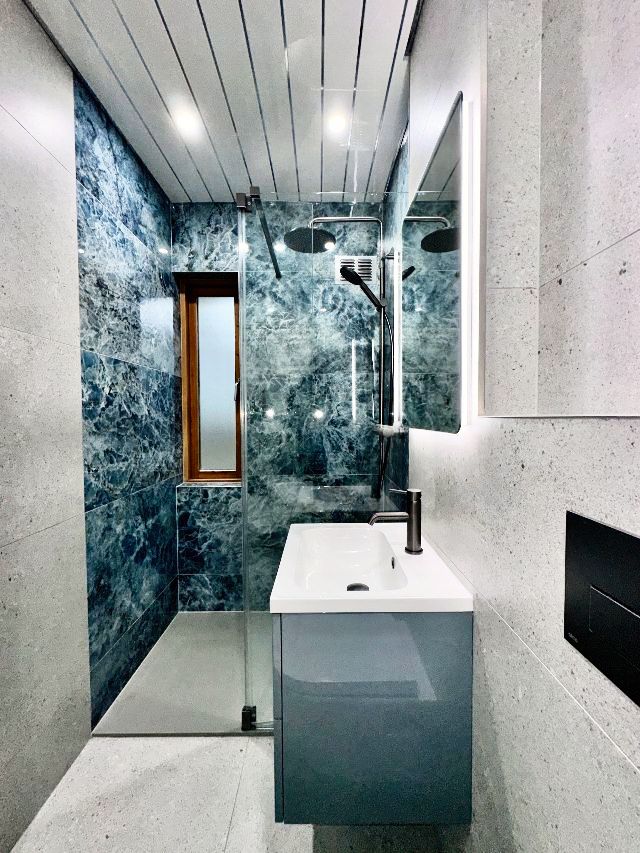 A bathroom with a sink and a walk in shower