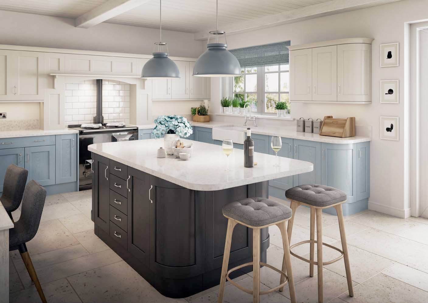 A kitchen with blue and white cabinets and a large island in the middle.