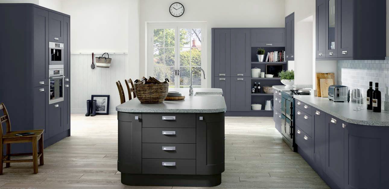 A kitchen with a large island in the middle and a clock on the wall.