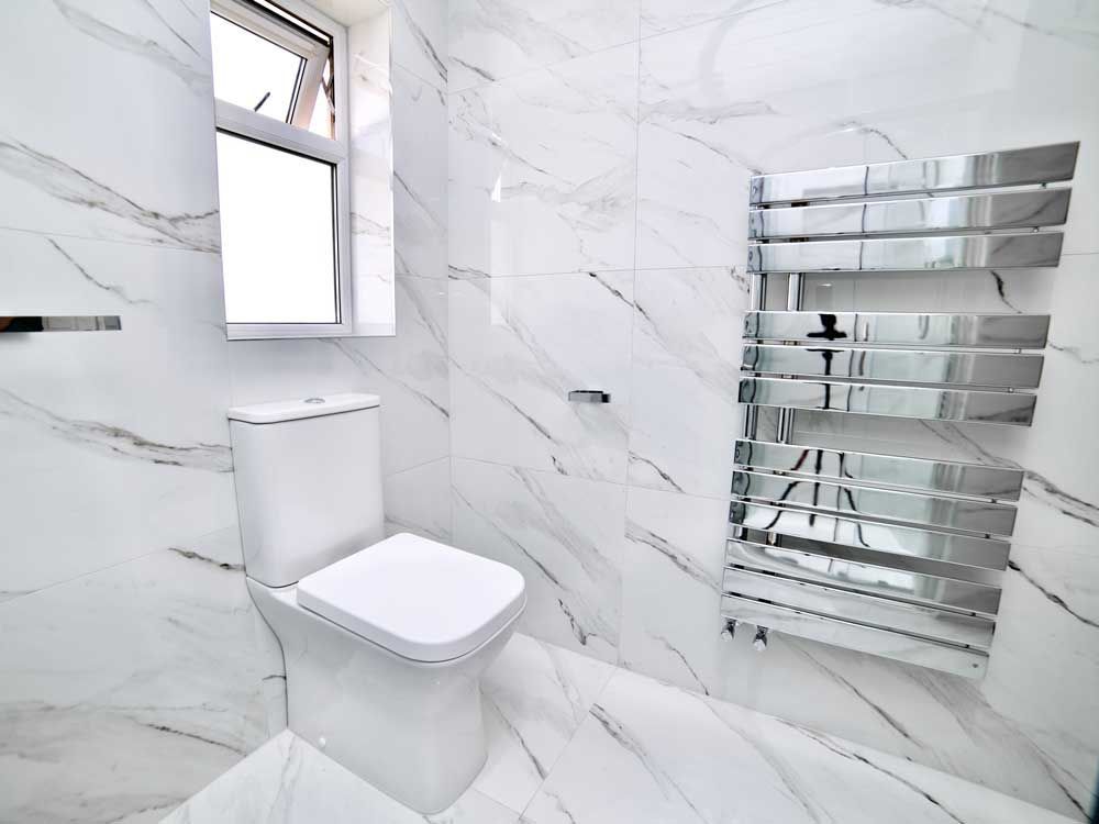 A bathroom with a toilet and a towel rack
