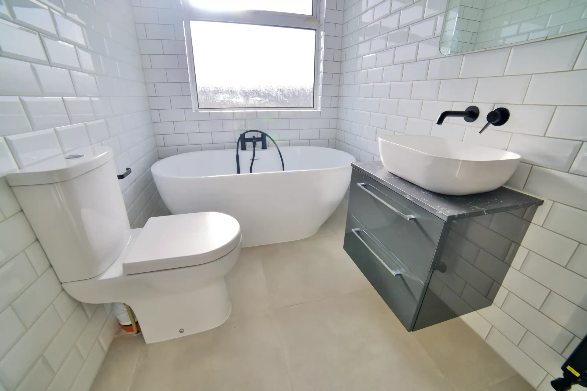 A bathroom with a toilet , sink and bathtub.