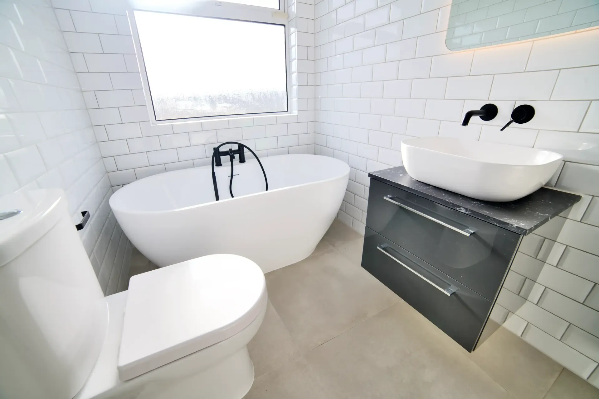 A bathroom with a bathtub , toilet , sink and mirror.