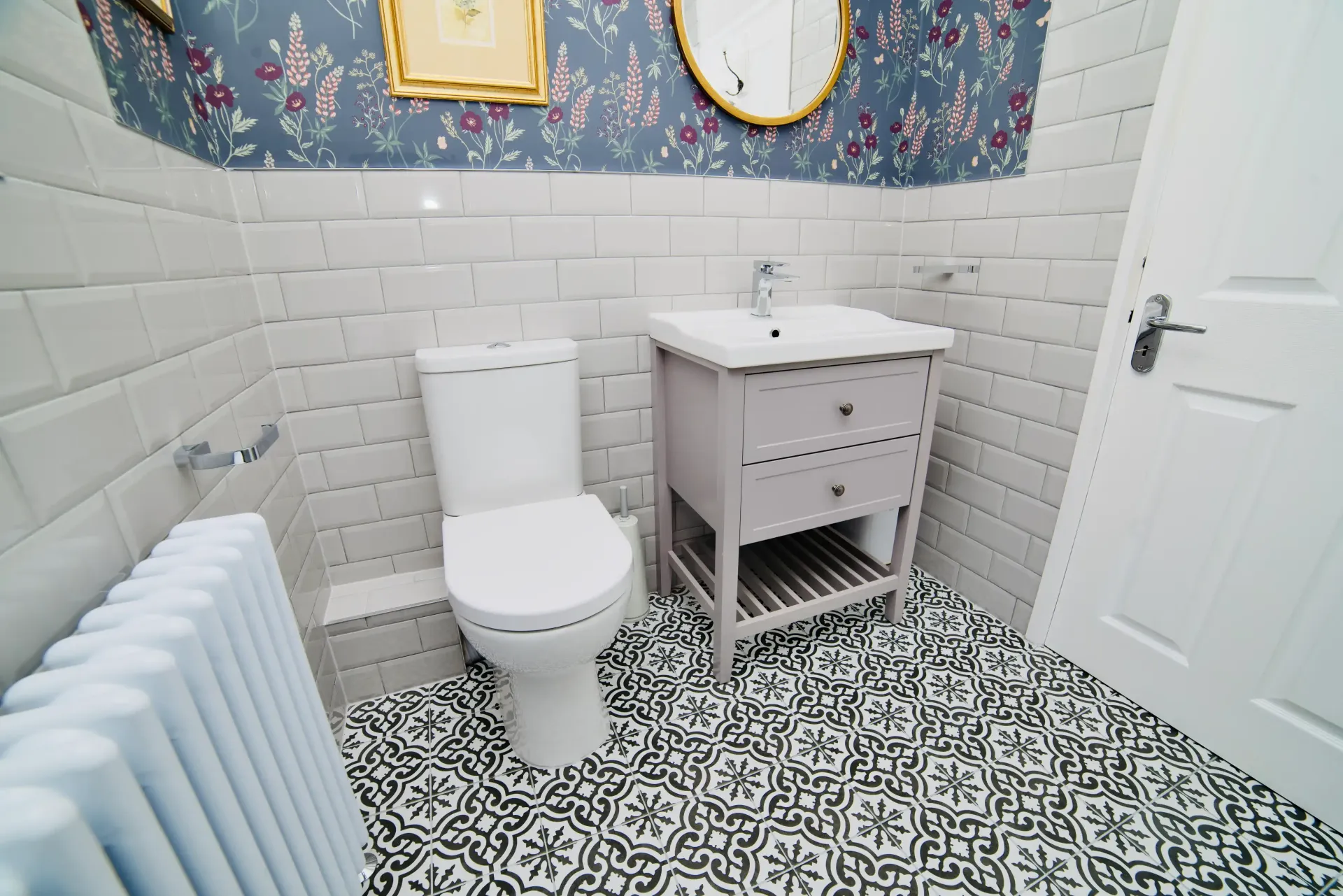 A bathroom with a toilet , sink and mirror.