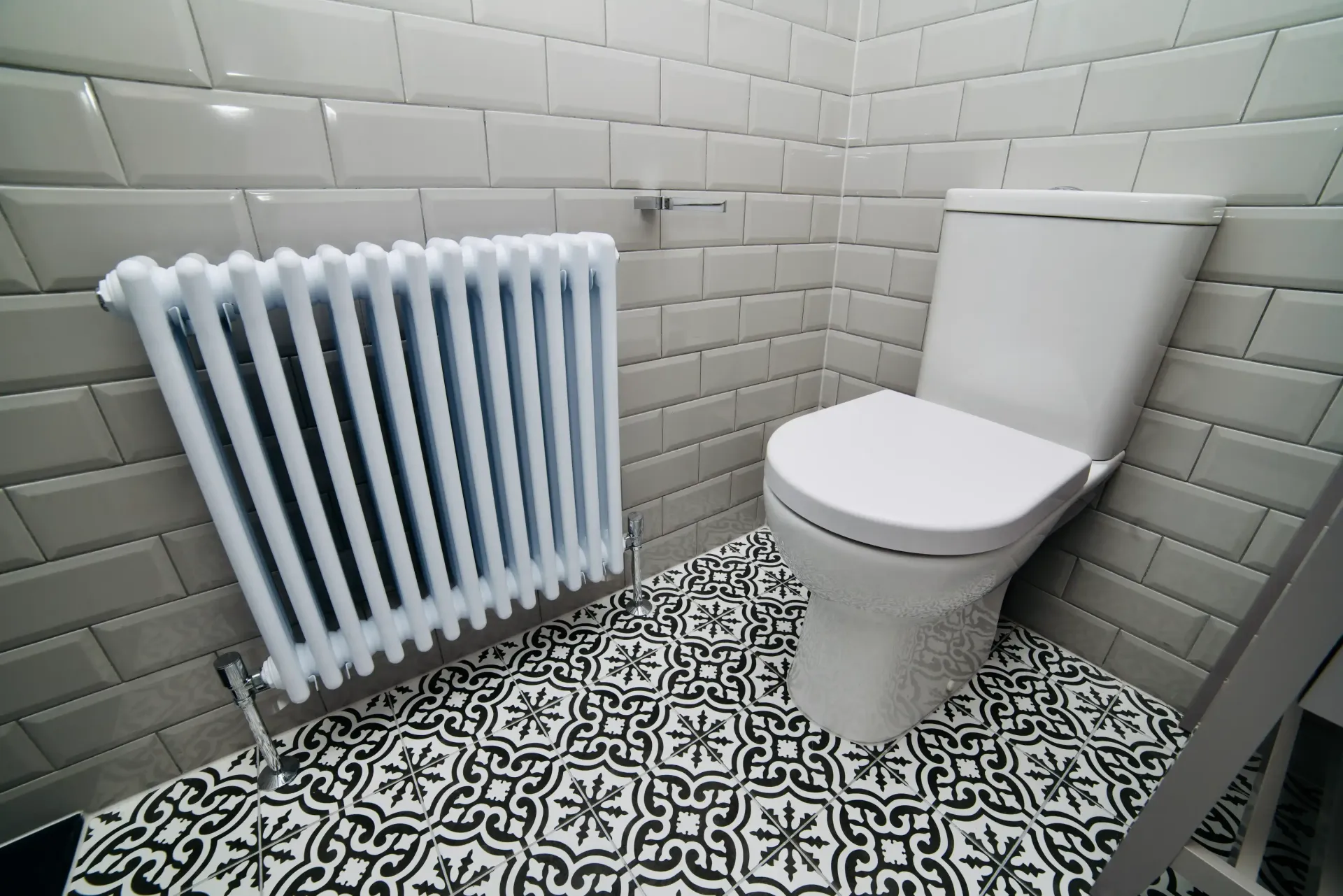 There is a toilet and a radiator in the bathroom.