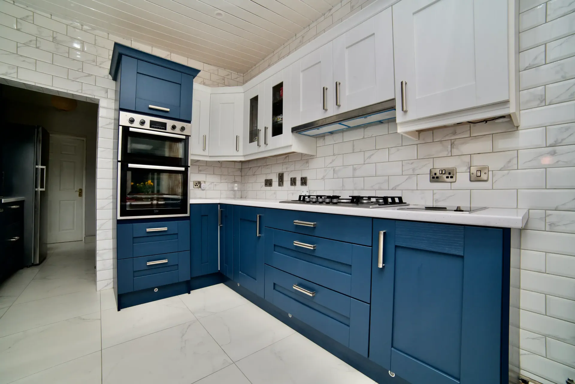 A kitchen with blue cabinets and white counter tops