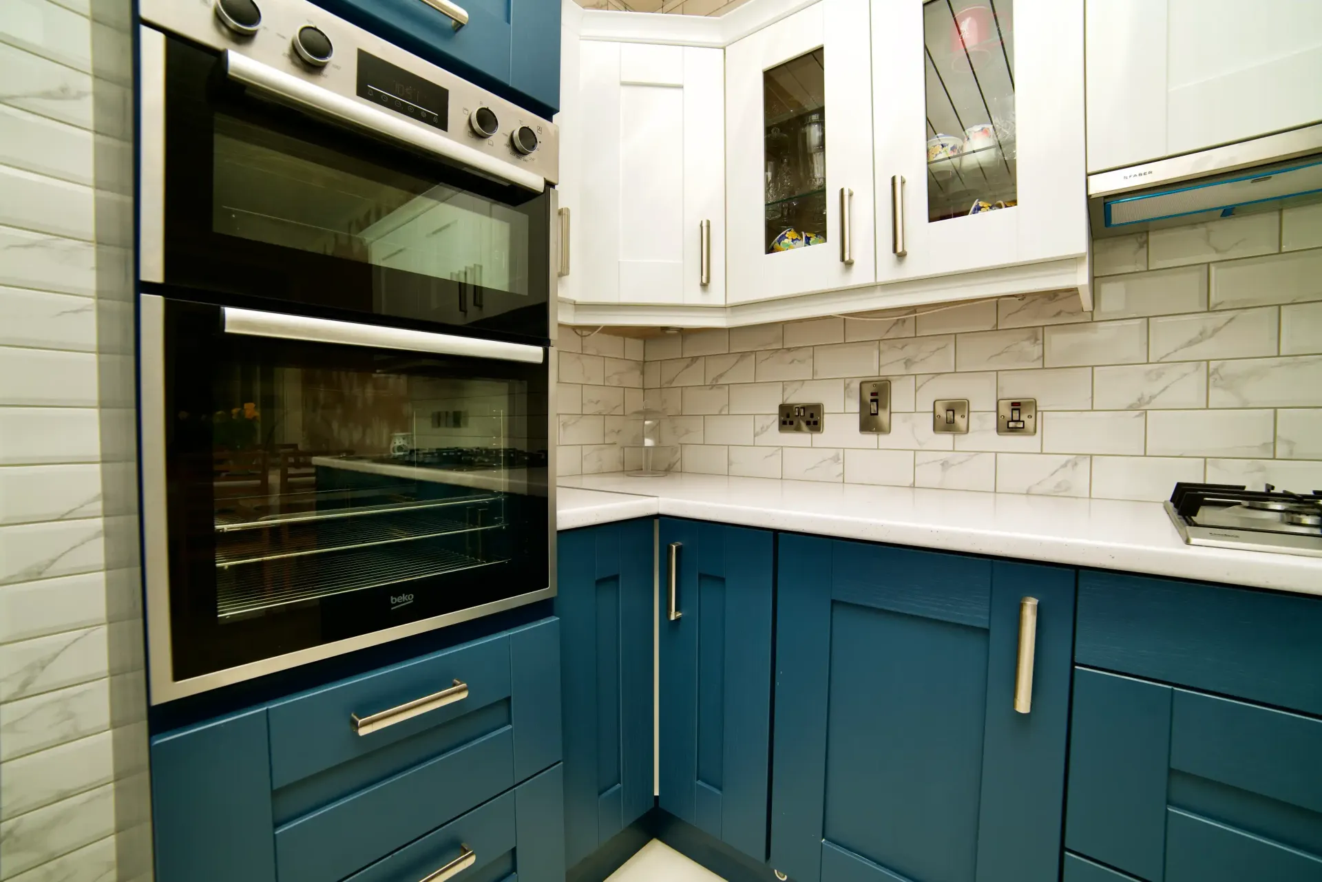 A kitchen with blue cabinets and a black oven