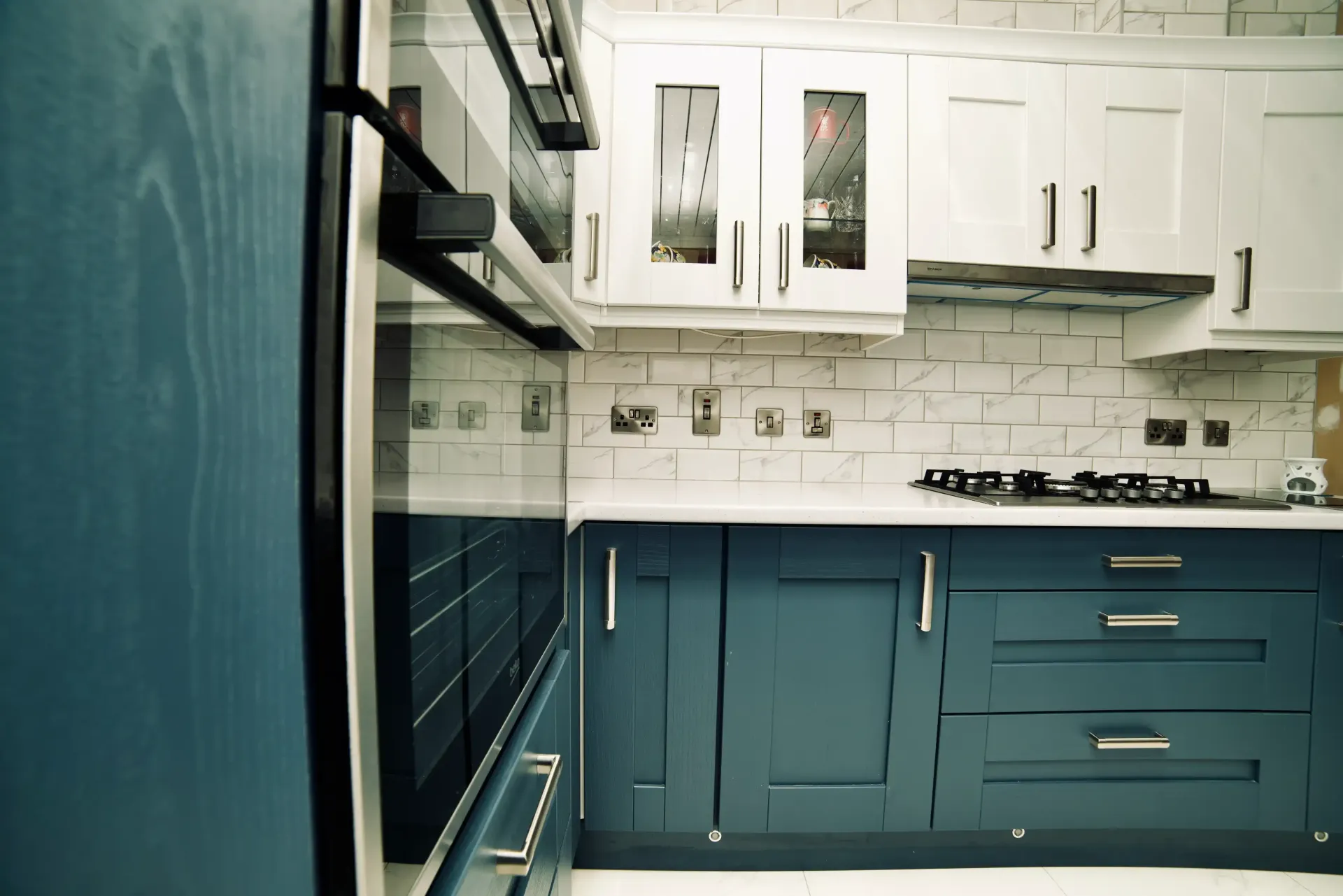 A kitchen with blue cabinets and white counter tops