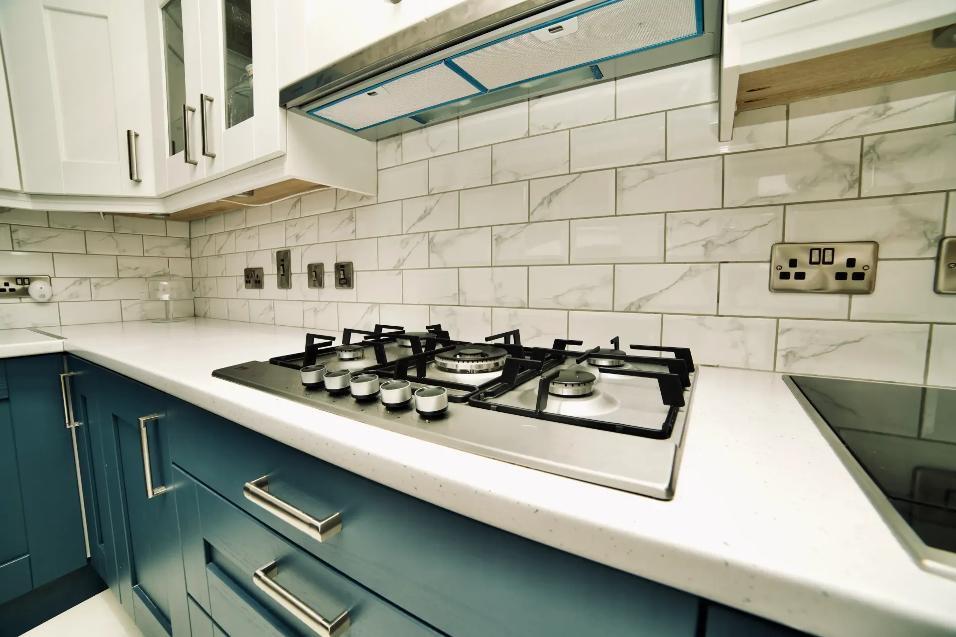 A kitchen with blue cabinets and a stove top oven.