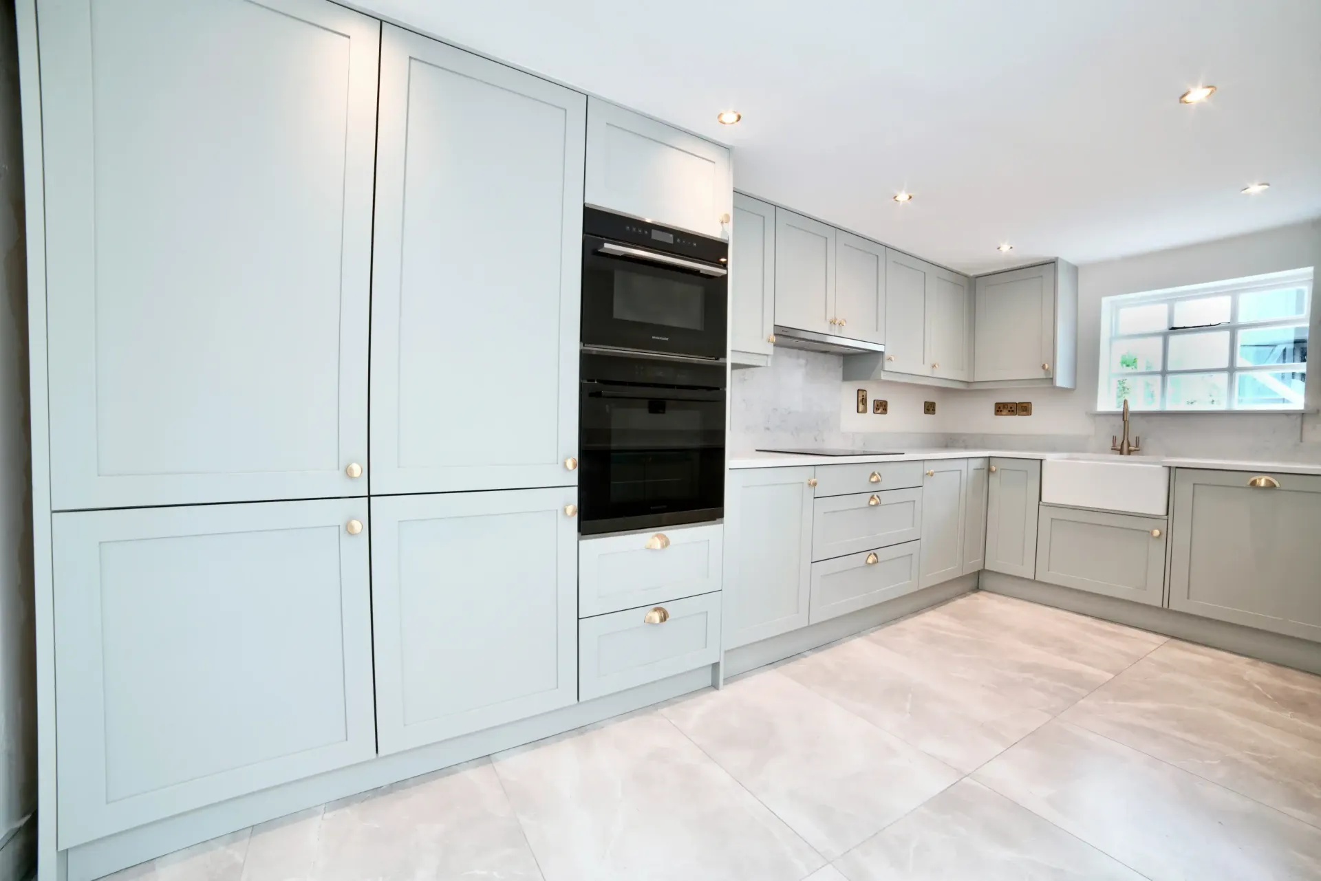 A kitchen with white cabinets and a black oven.