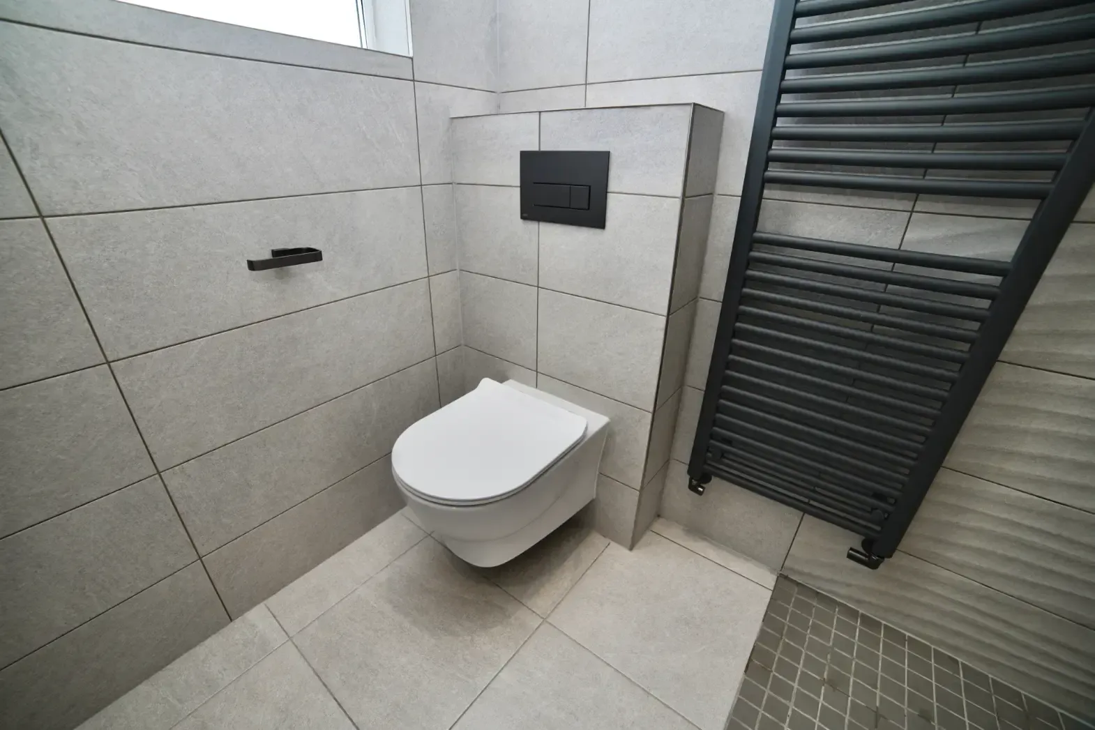 A bathroom with a toilet and a towel rack
