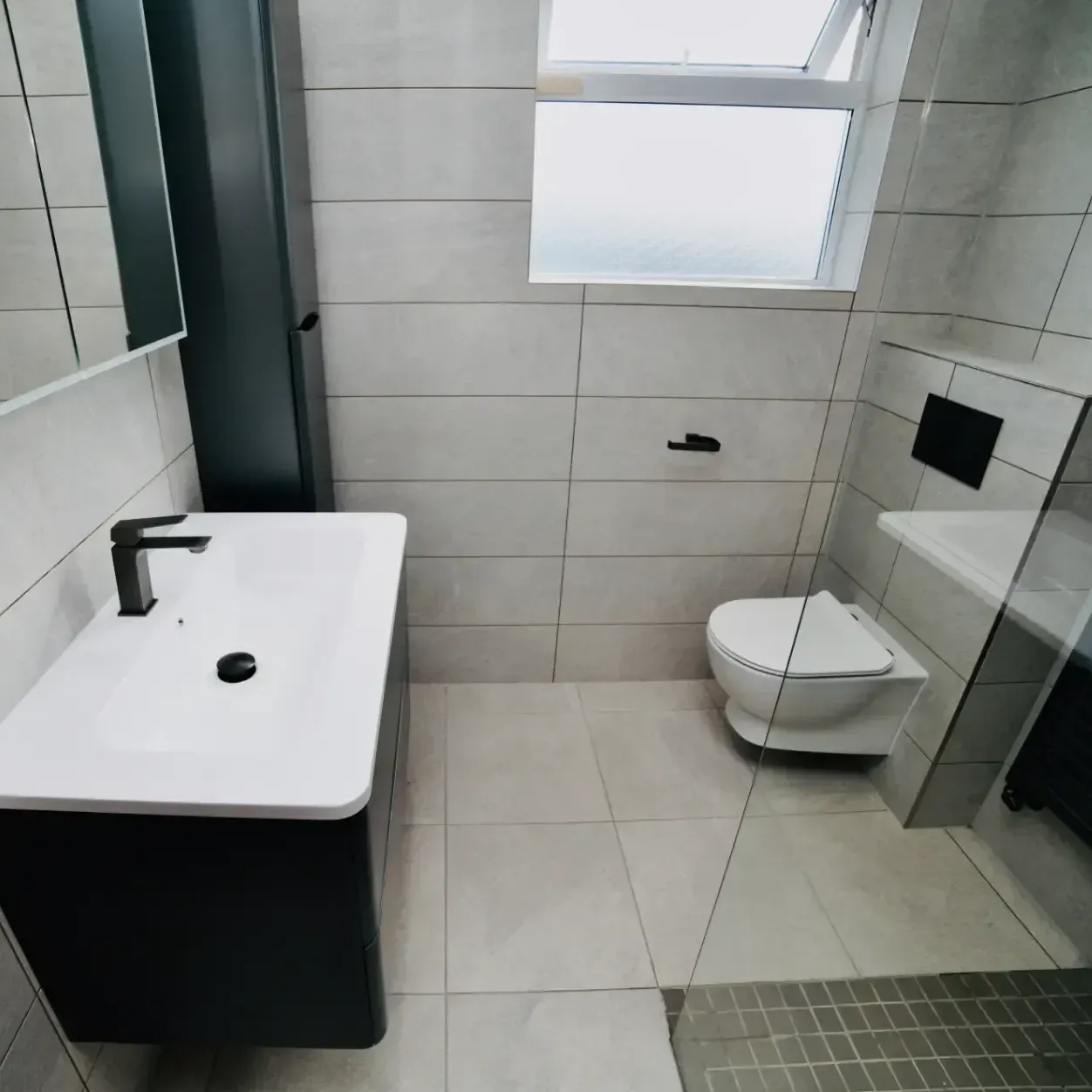 A bathroom with a sink toilet and mirror