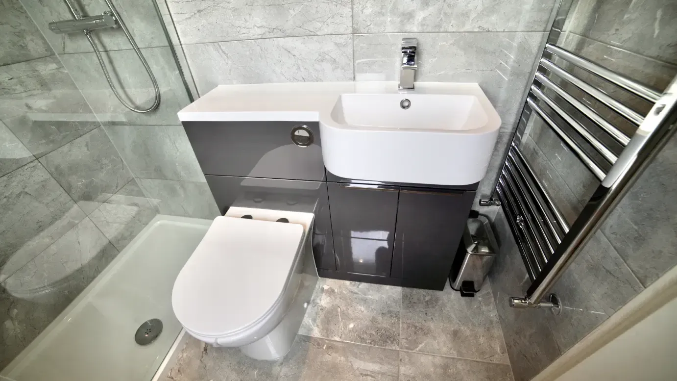 A bathroom with a toilet , sink , and shower.