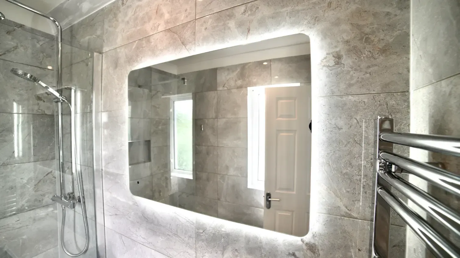 A bathroom with a large mirror and a towel rack.