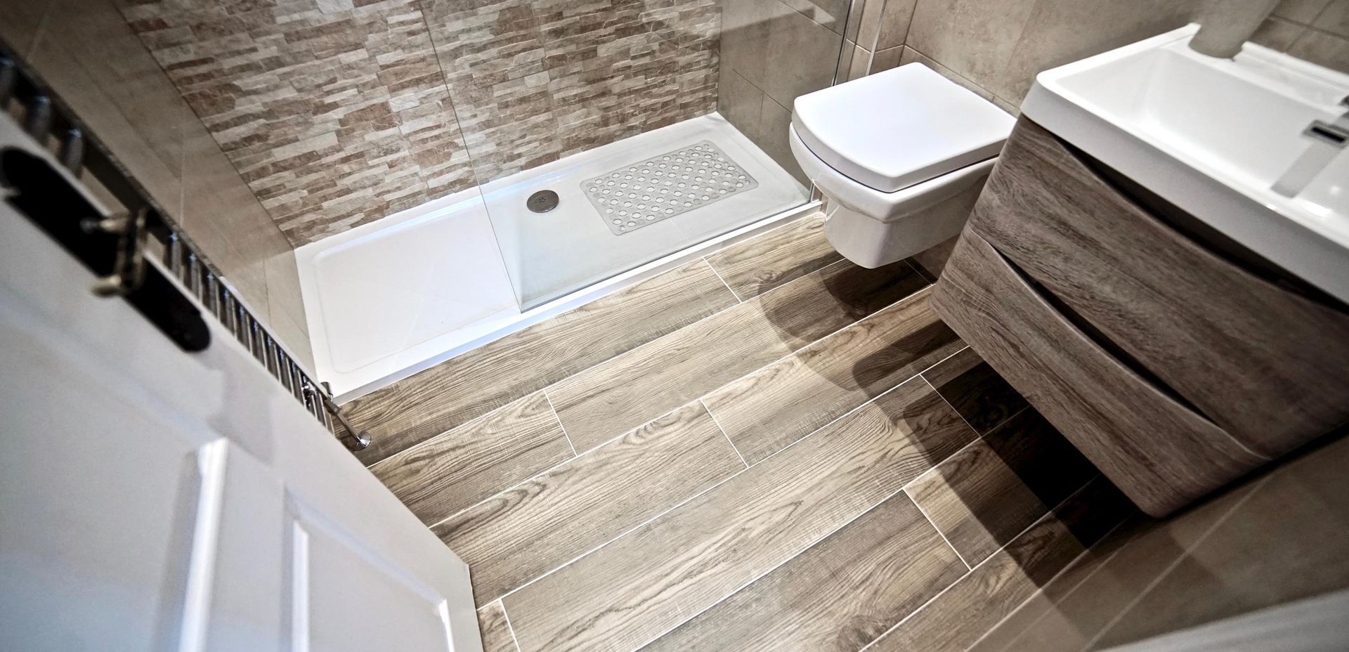 A bathroom with a toilet , sink , and shower.