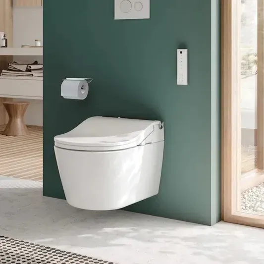 A white toilet is mounted to a green wall in a bathroom.