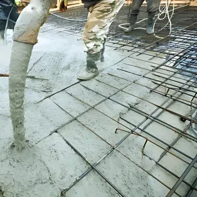 Concrete contractors are pumping onto a foundation, showcasing regulatory expertise in Dunedin.