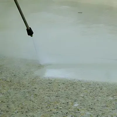 The Dunners Concrete team is washing down a freshly placed exposed aggregate driveway in Dunedin.
