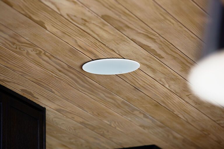 Recessed  speaker in a wooden plank ceiling.