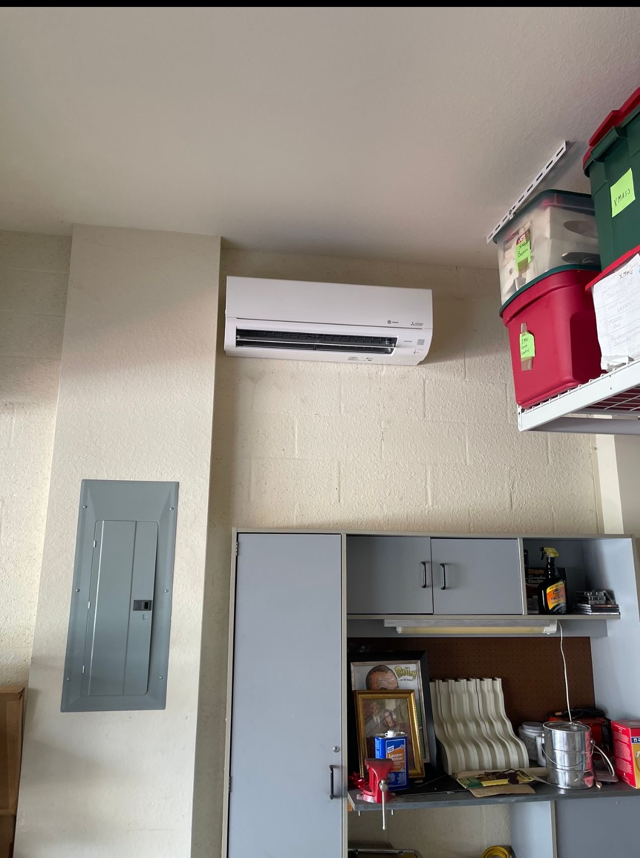 A room with boxes hanging from the ceiling and a wall mounted air conditioner