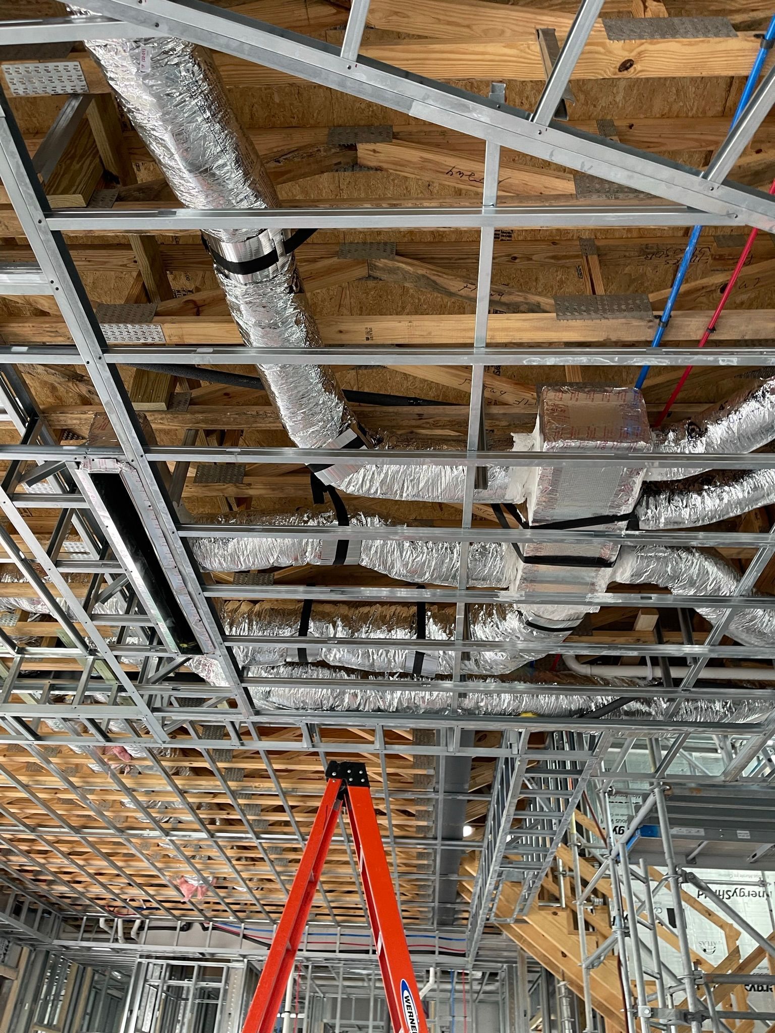 A ladder is sitting in the ceiling of a building under construction.