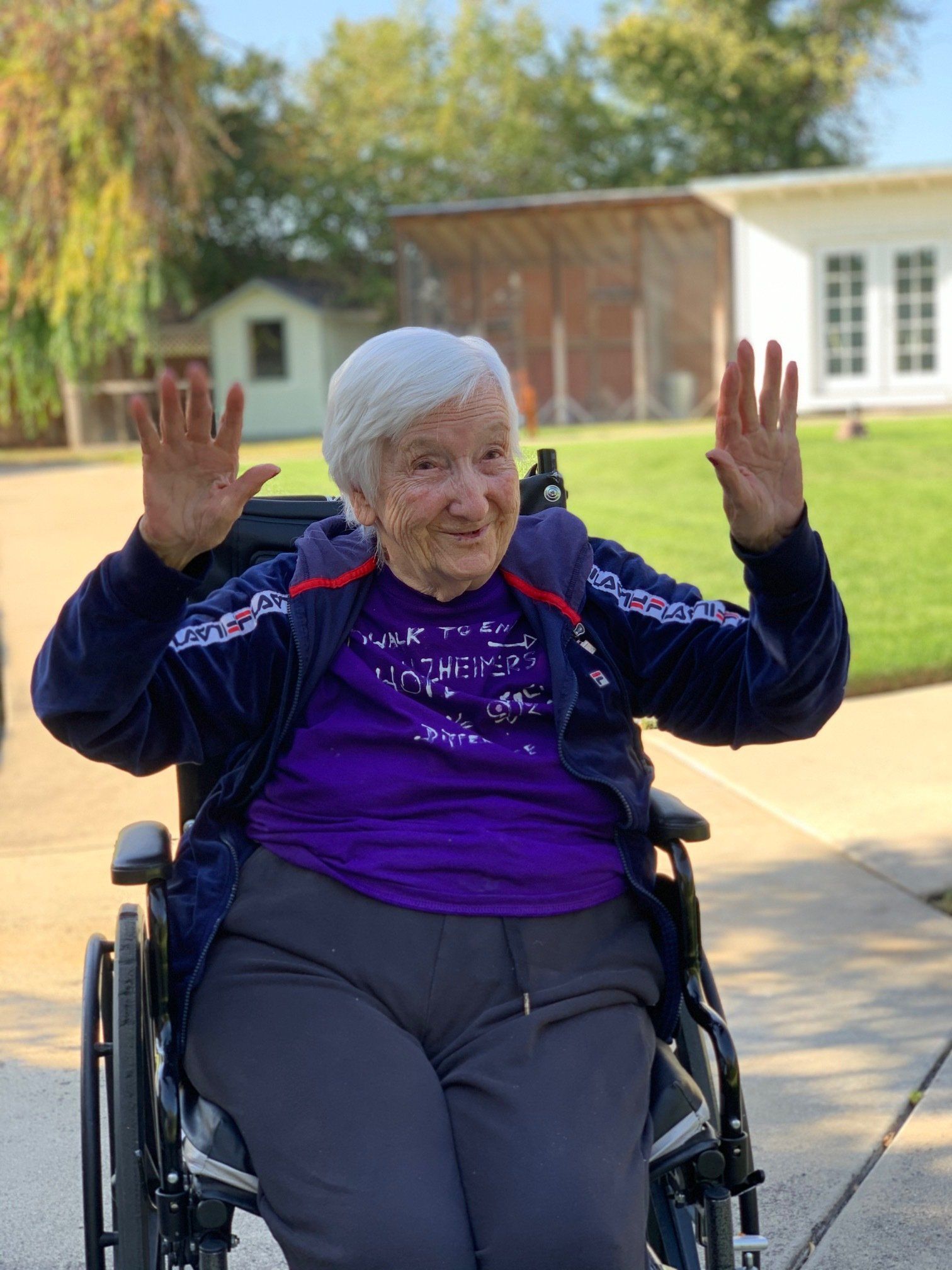dementia patient in wheelchair excitedly raising her arms