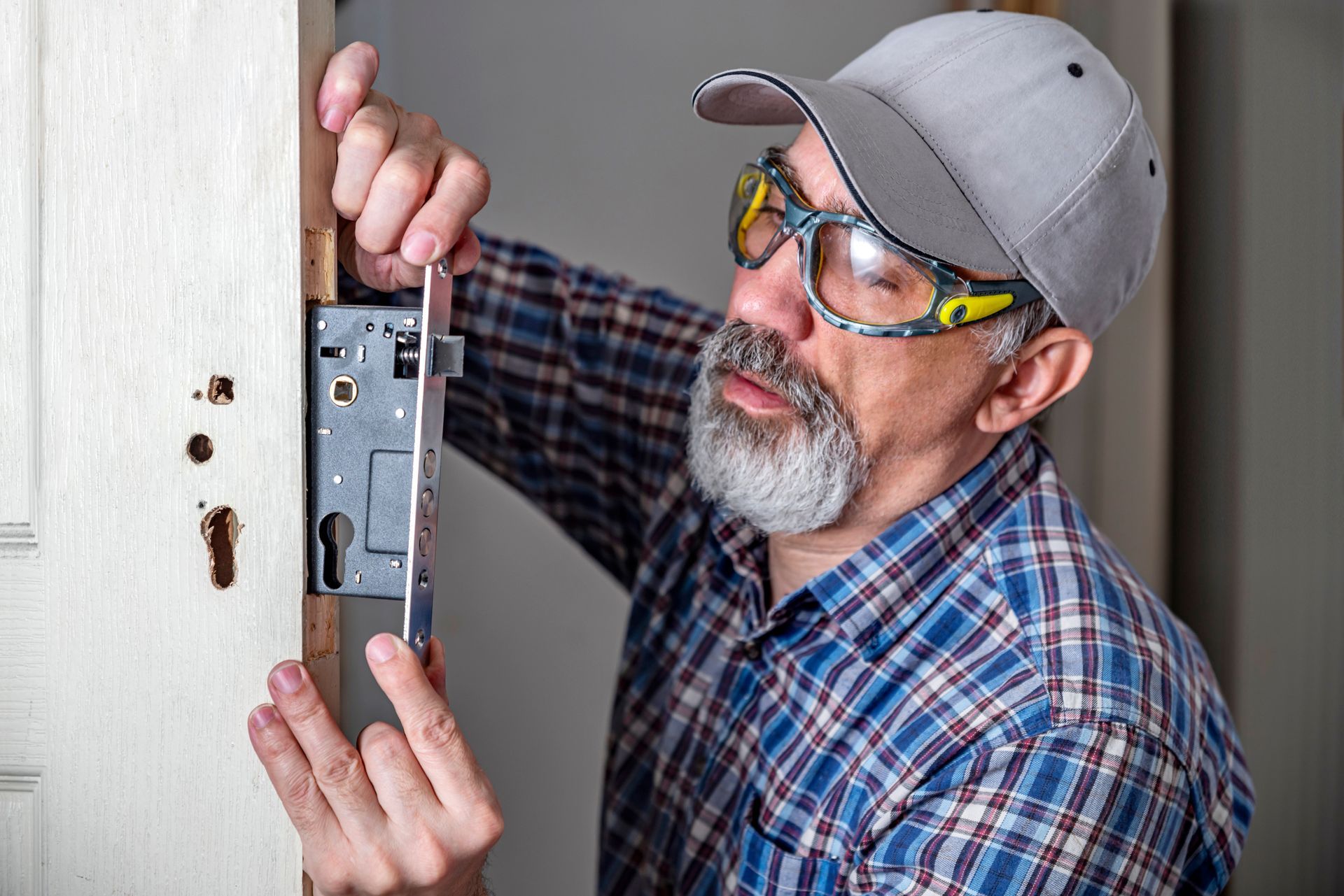 A residential locksmith installing a new lock for better security. A residential locksmith installing a new lock for better security.