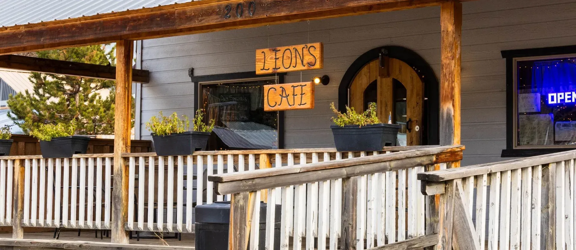 Exterior view of Lion's Cafe, wooden building with a porch. Sign says