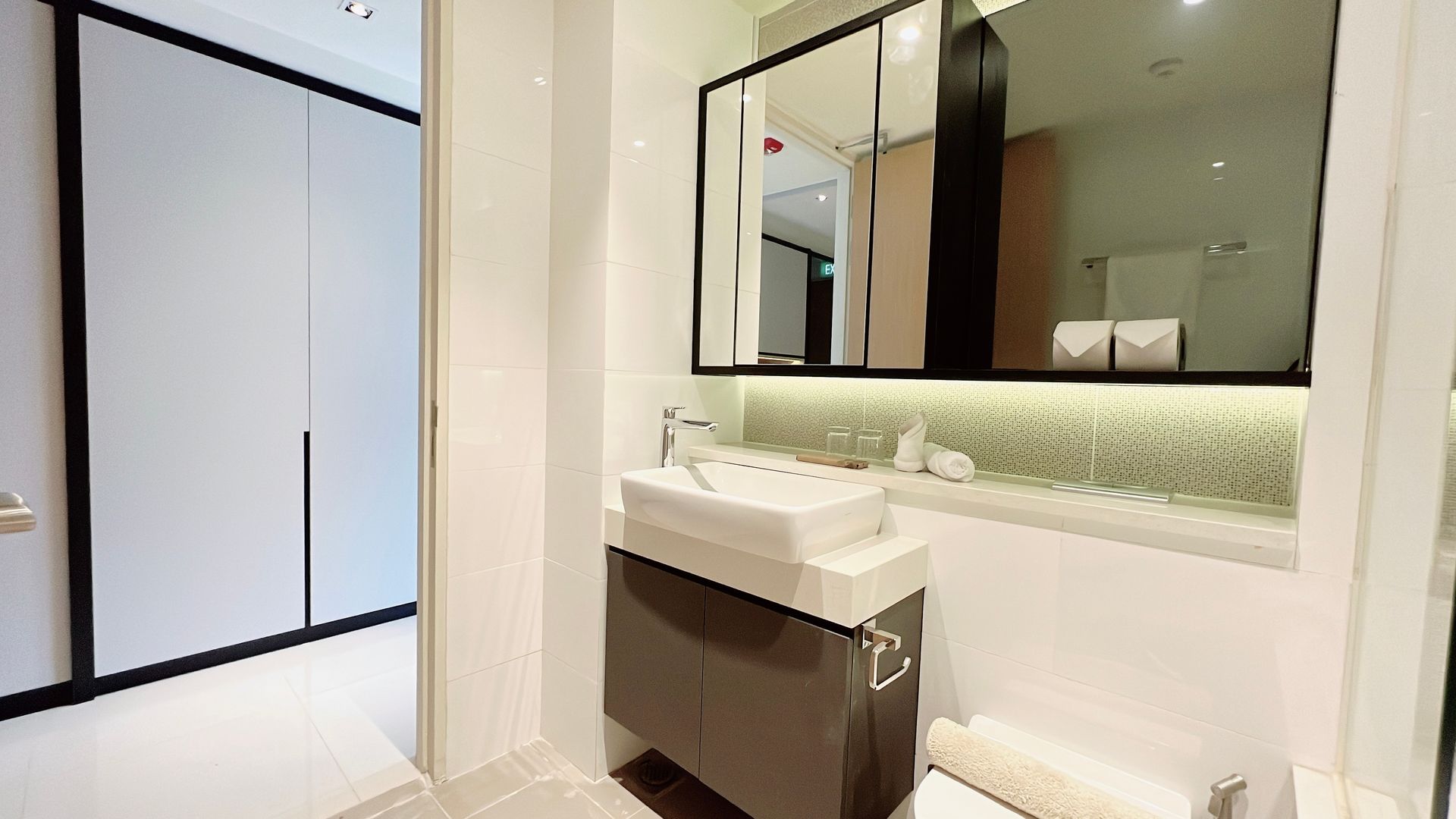Modern bathroom with sink, large mirror, and glass shower enclosure