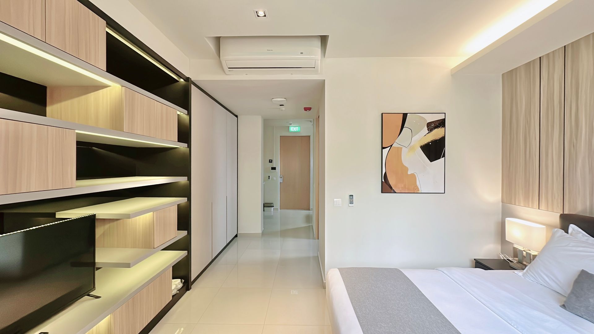 Modern bedroom with built-in shelving, a bed, beige curtains, and minimalist wall art