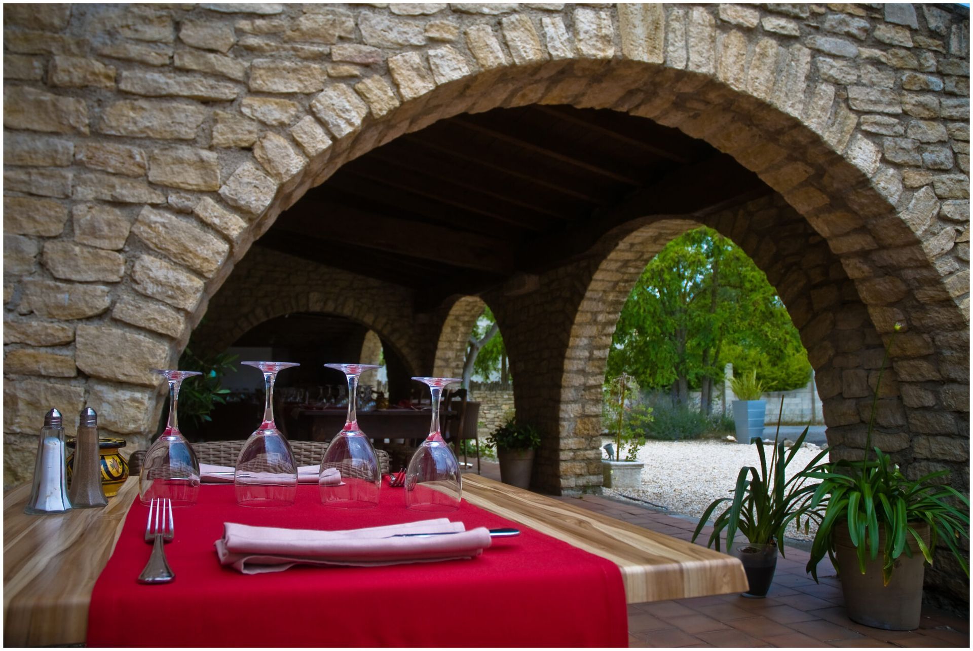 Une table avec des verres à vin dessus sous une arche en pierre