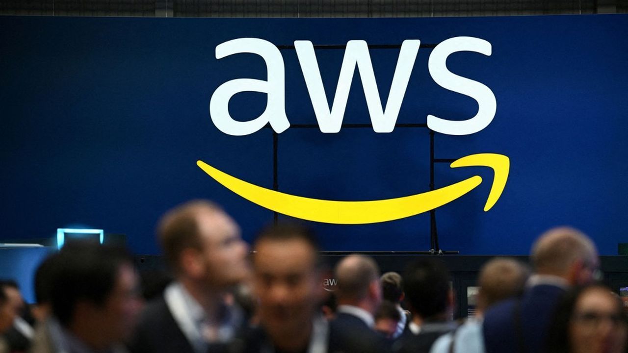 AWS logo on a blue backdrop; audience in the foreground.