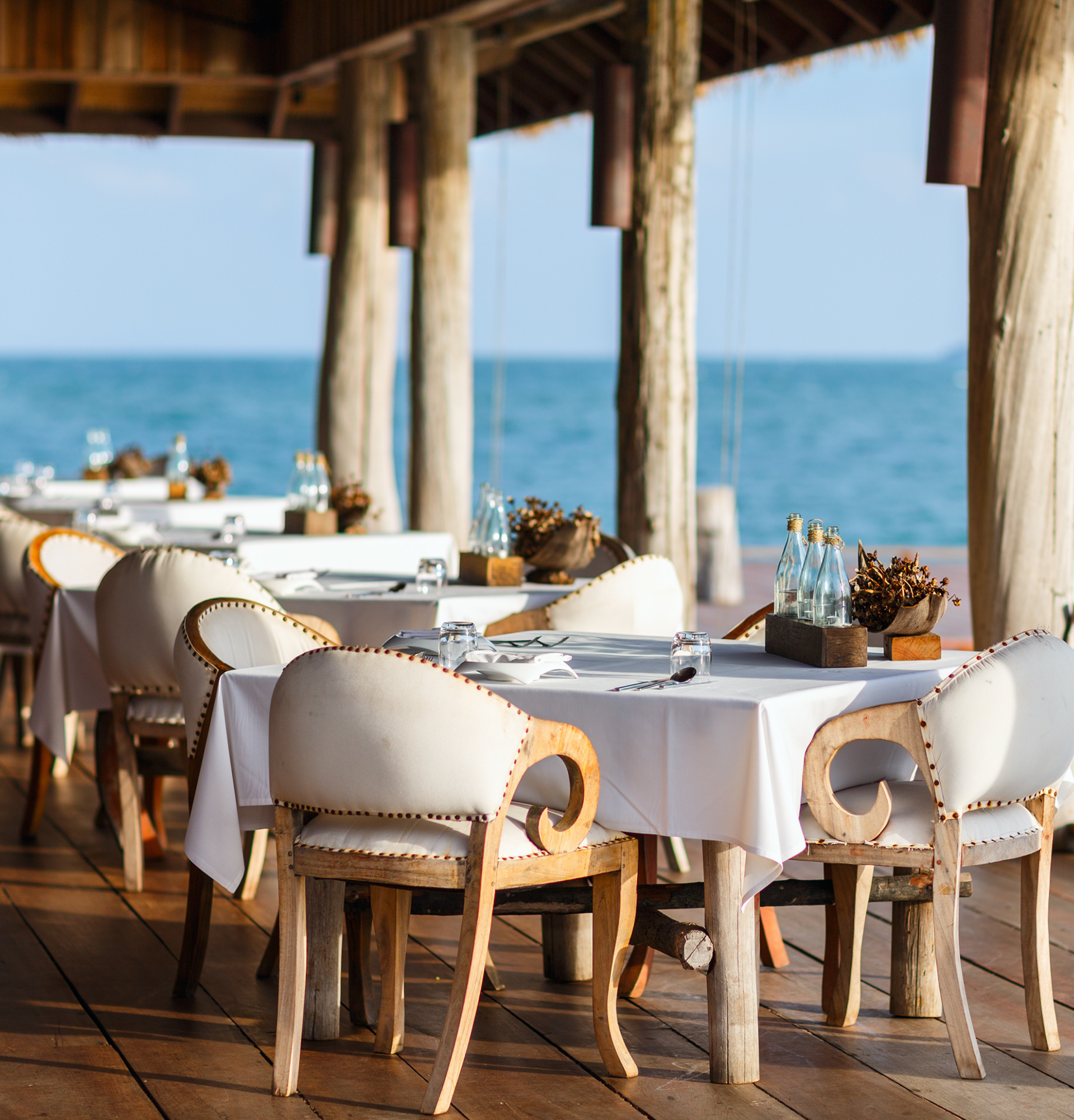 Un restaurant avec des tables et des chaises donnant sur l'océan