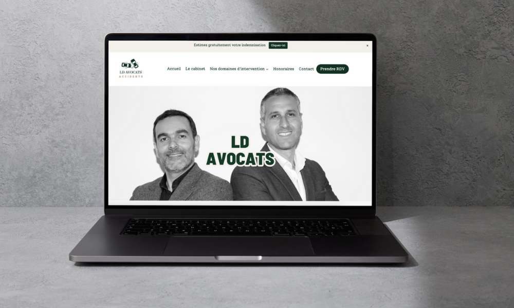 Un ordinateur portable est ouvert sur un site Web avec deux hommes sur l'écran.