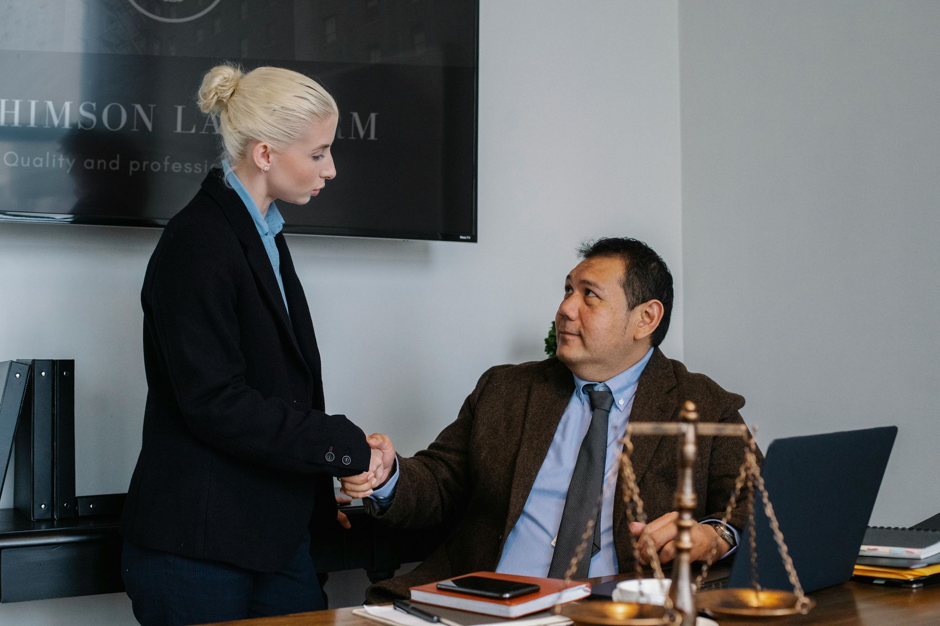 Un homme et une femme se serrent la main dans un bureau.