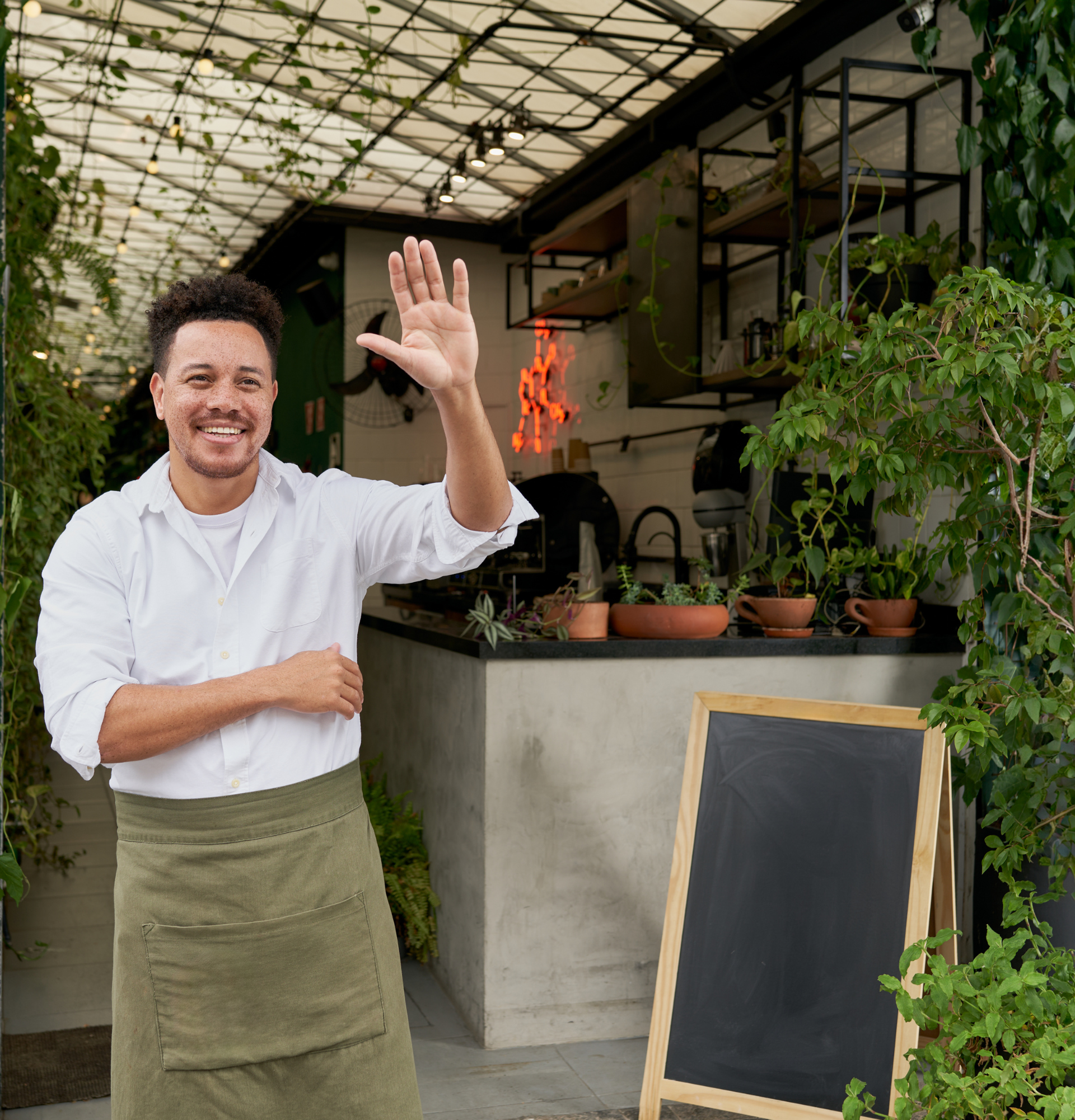 Un homme en tablier fait signe devant un restaurant