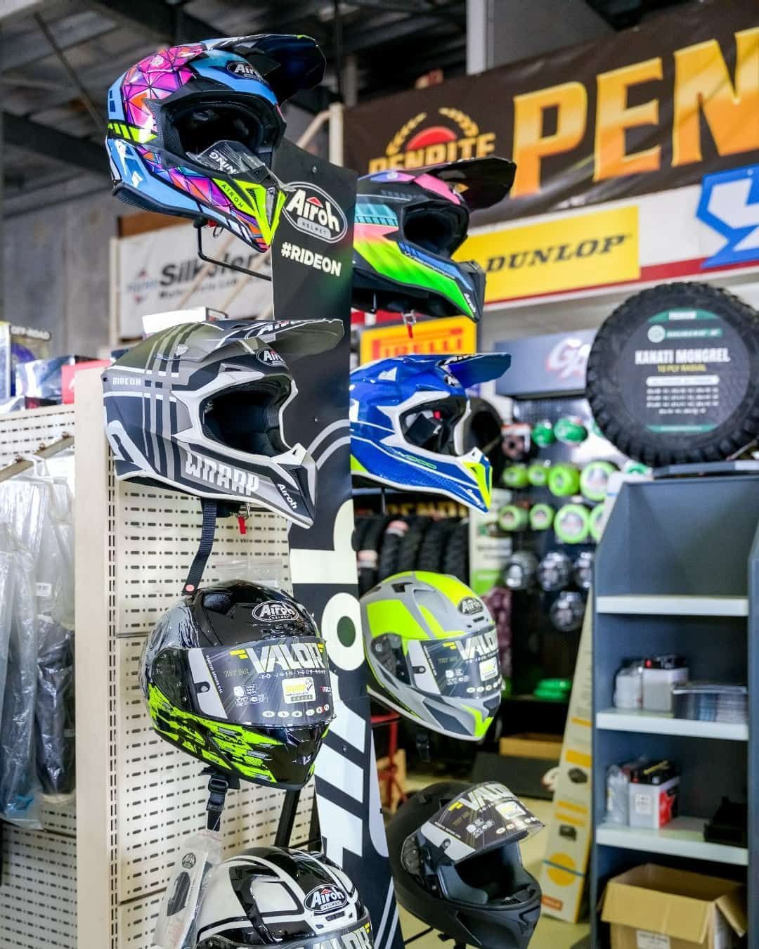 A Bunch Of Motorcycle Helmets Are Hanging On A Rack In A Store — Coastal Farm & Motorcycles In Innisfail, QLD