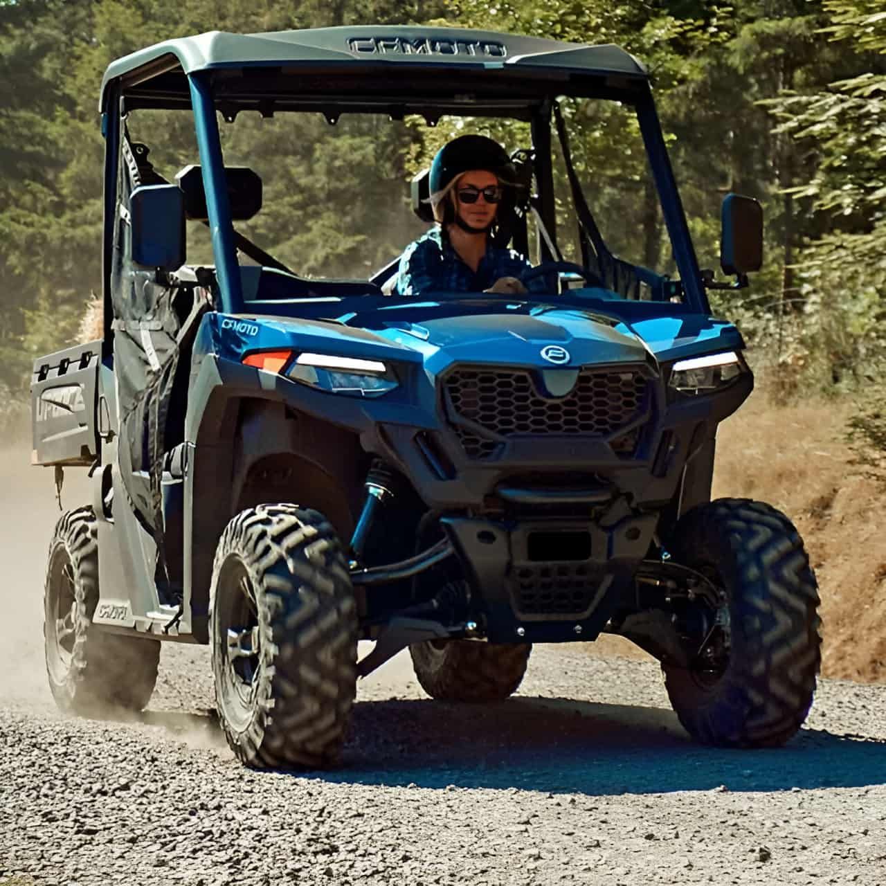 A Man Is Driving A Blue ATV On A Dirt Road — Coastal Farm & Motorcycles In Innisfail, QLD