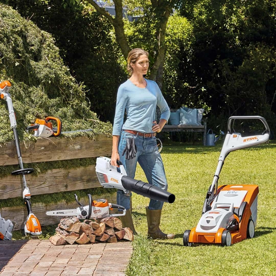 A Woman Is Standing Next To A Lawn Mower Holding A Blower — Coastal Farm & Motorcycles In Innisfail, QLD