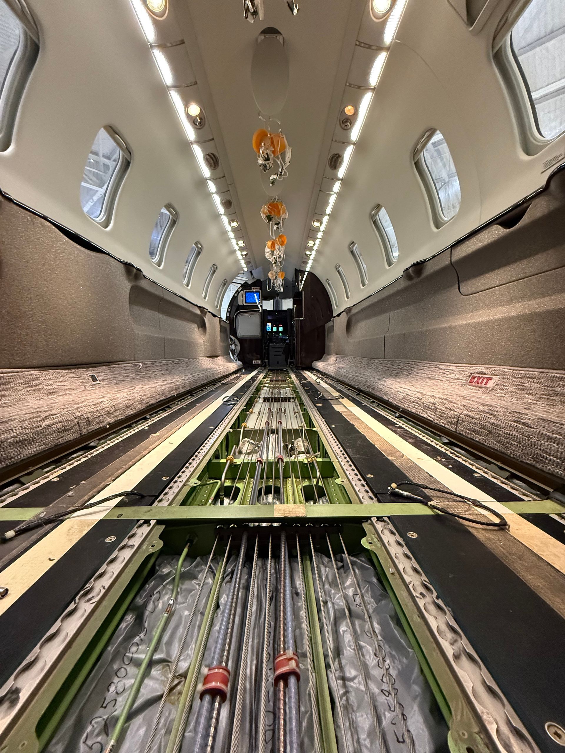 A man is working on an airplane engine in a factory.