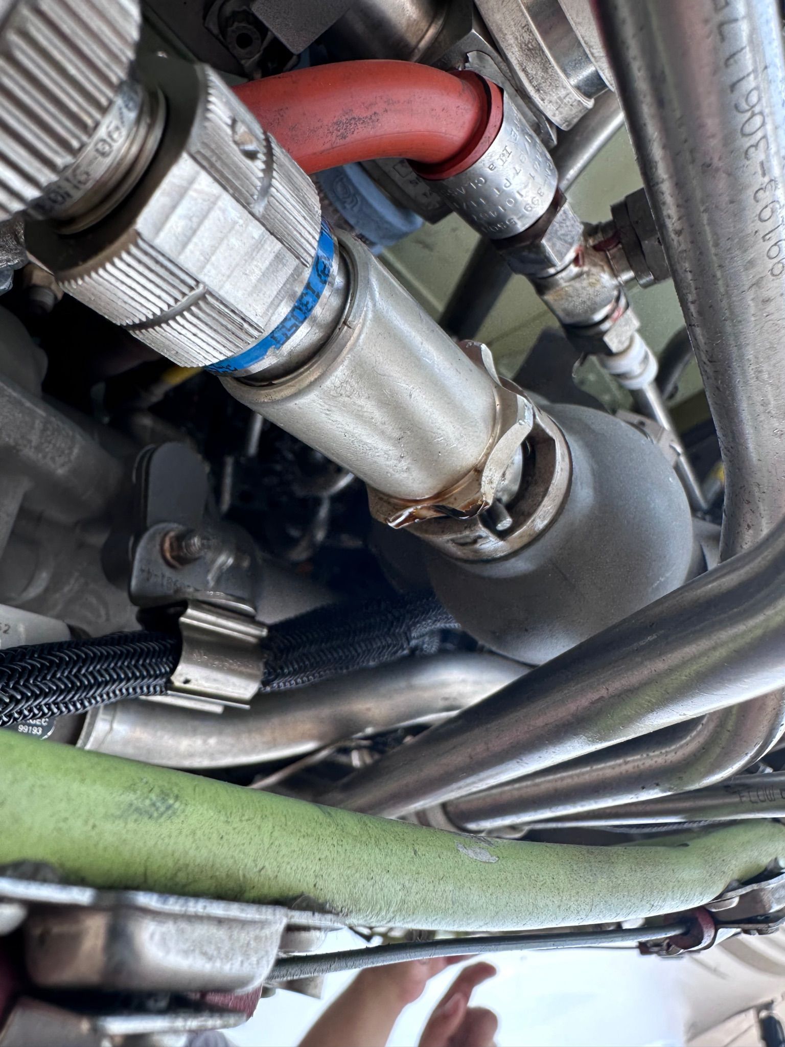 Two men are working on an airplane engine in a hangar.