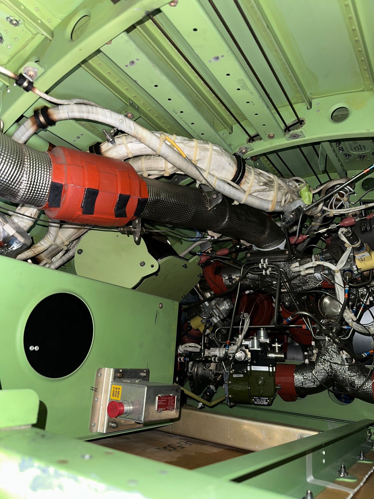 A man is working on an airplane engine in a factory.