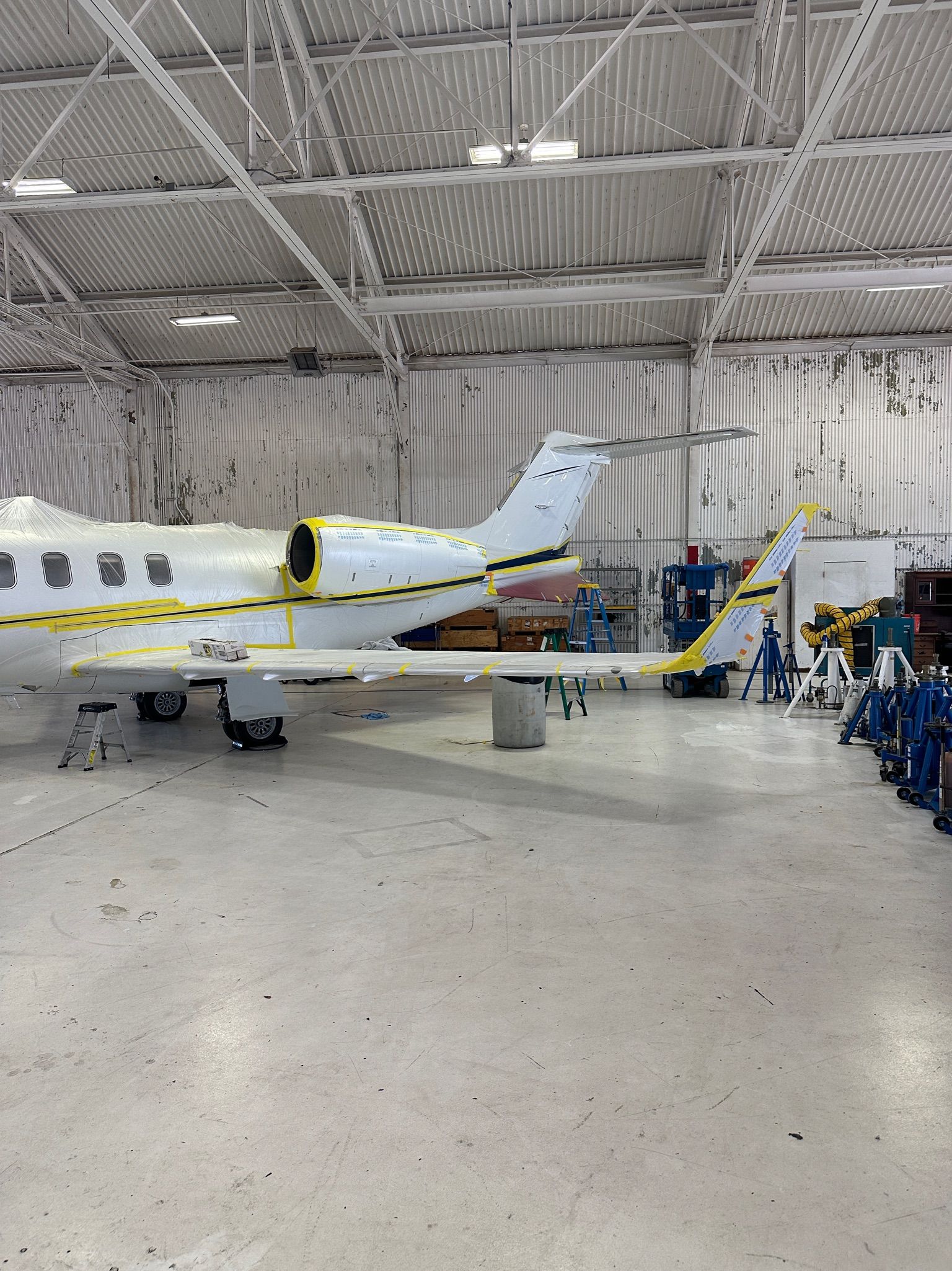 Two airplanes are being built in a hangar.